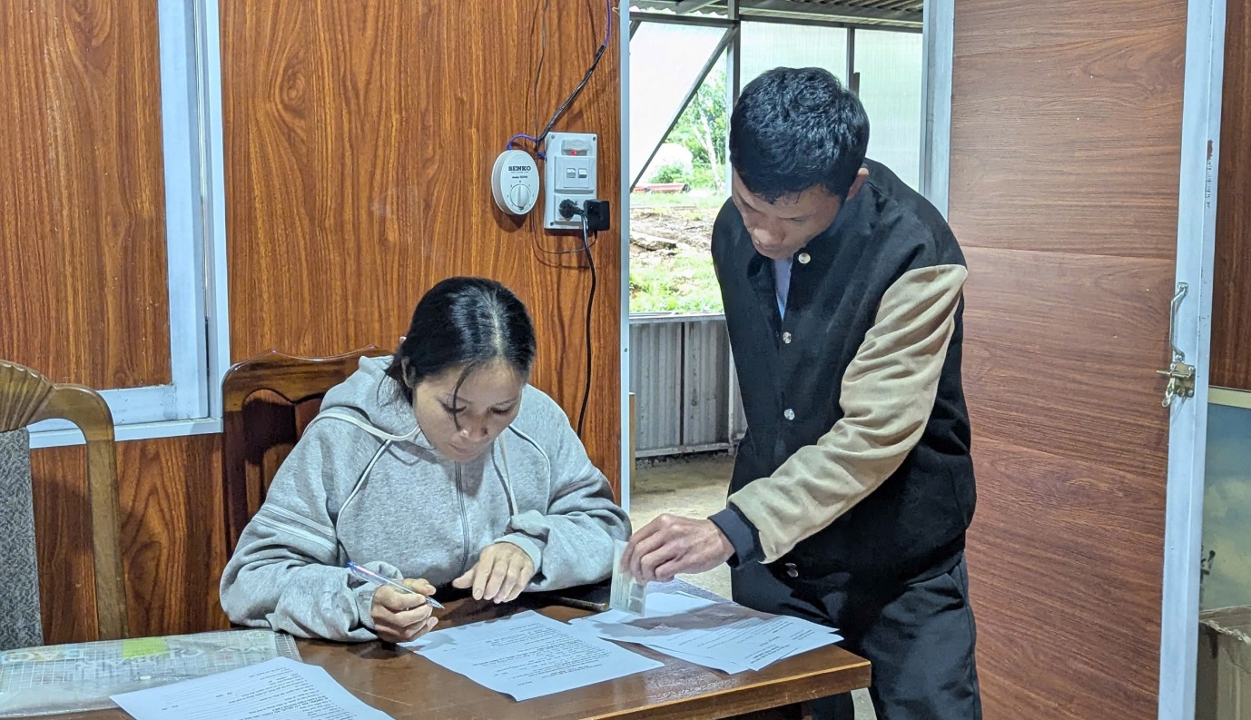 Chị Y Tiết người dân thôn Điek Nót được công chức chuyên môn hỗ trợ hướng dẫn tận tình về thủ tục hồ sơ bảo trợ xã hội.